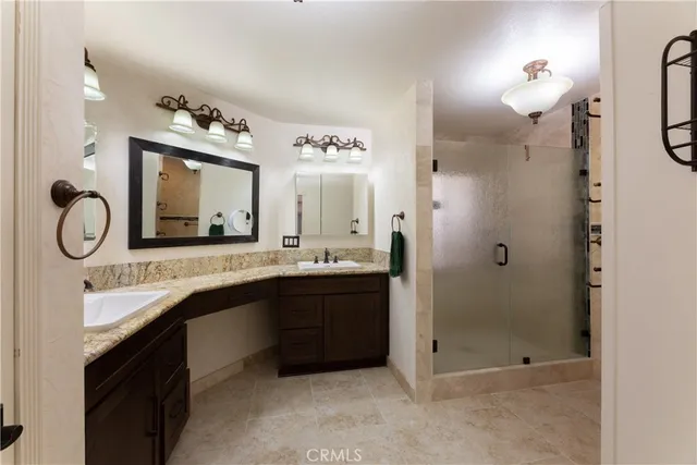 a bathroom with a double vanity sink mirror and shower