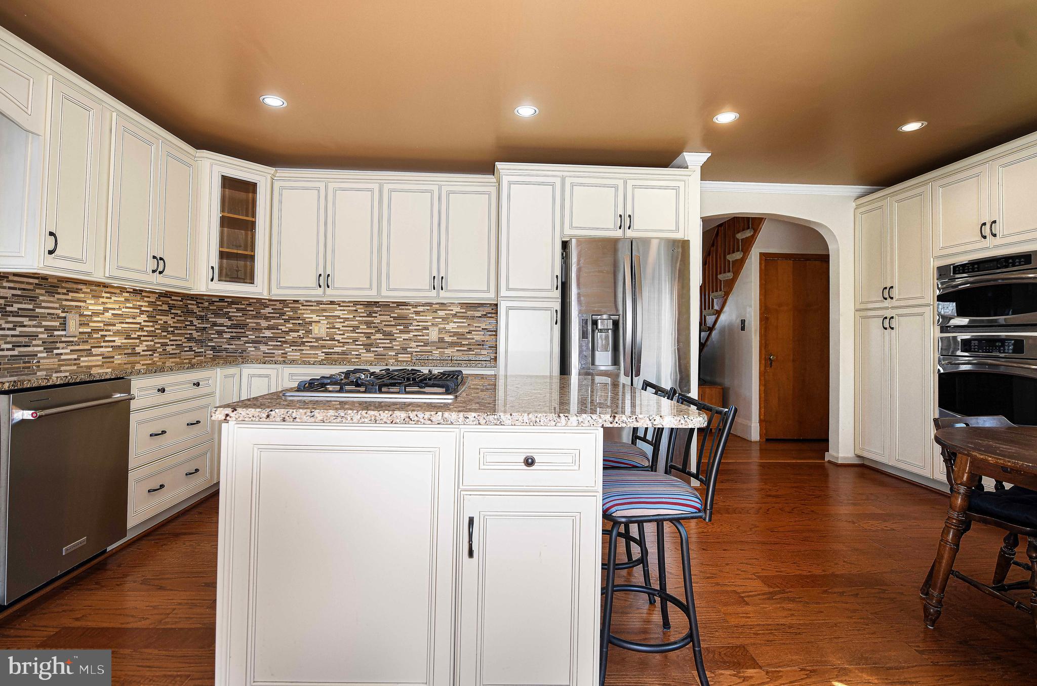 922 Rock Spring Road Bel Air, MD 21014 - Photo 18 of 69 a kitchen with stainless steel appliances kitchen island granite countertop a refrigerator a stove a sink a dining table and chairs with wooden floor