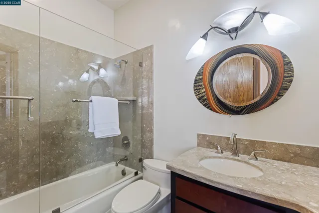 a bathroom with a granite countertop sink a potted plant and a large mirror