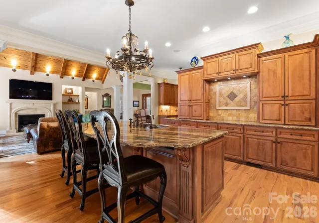 a kitchen with stainless steel appliances granite countertop a kitchen island hardwood floor and a sink