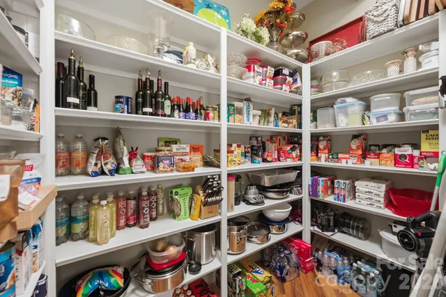 a spacious bedroom with a bed and glass walk in closet