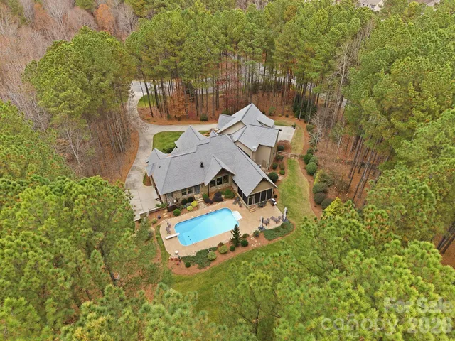 a front view of a house with a garden and trees