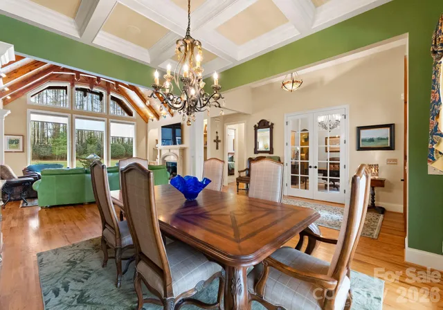 a view of a dining room with furniture a chandelier and wooden floor