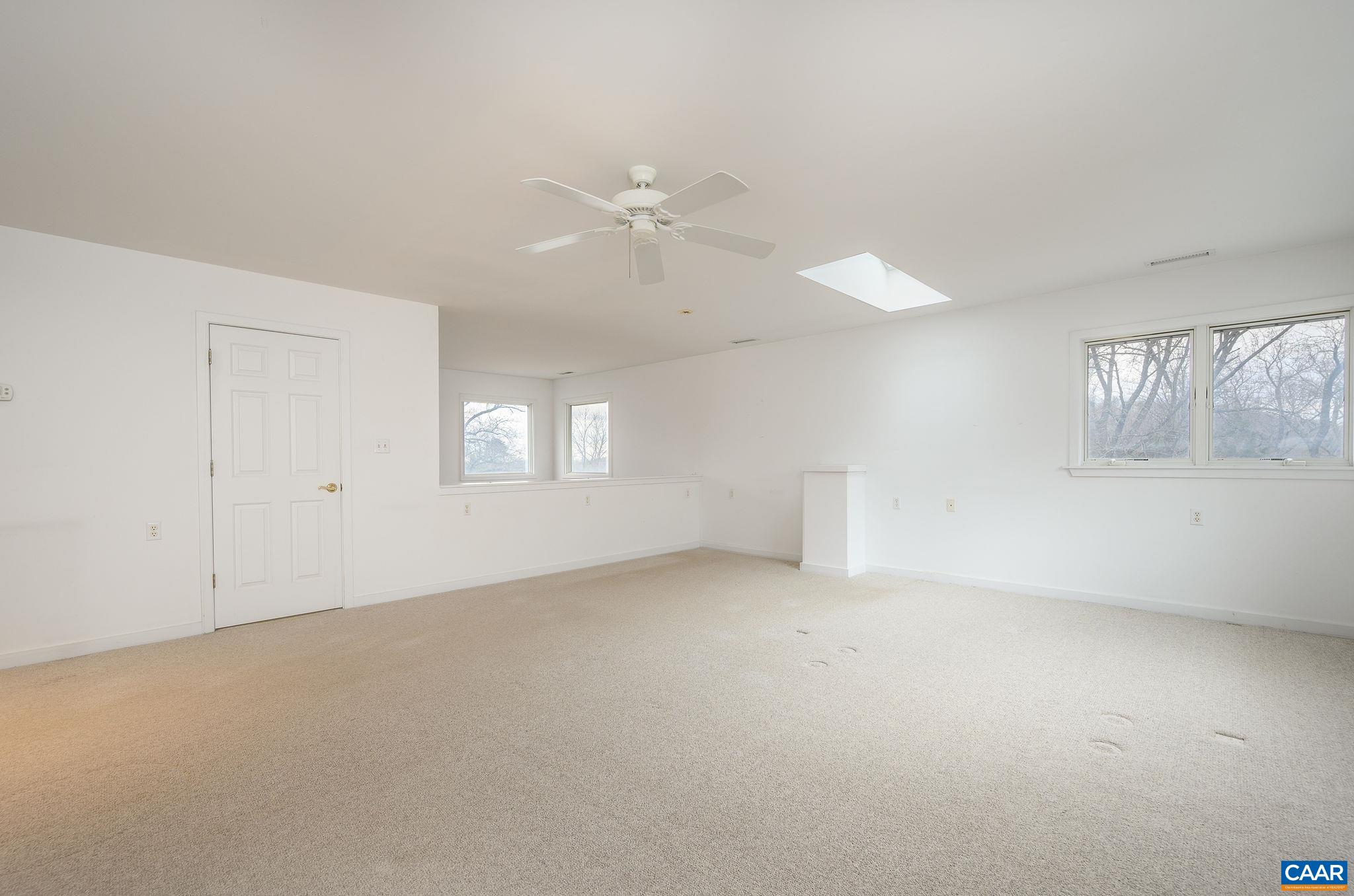 9165 Dick Woods Road Afton, VA 22920 - Photo 27 of 56 an empty room with windows and chandelier fan