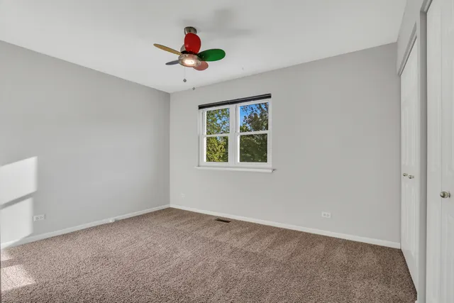 an empty room with window and ceiling fan