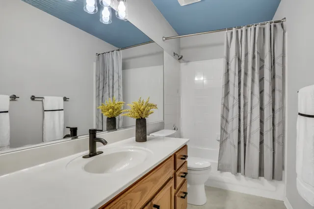 a bathroom with a granite countertop sink a toilet and a mirror