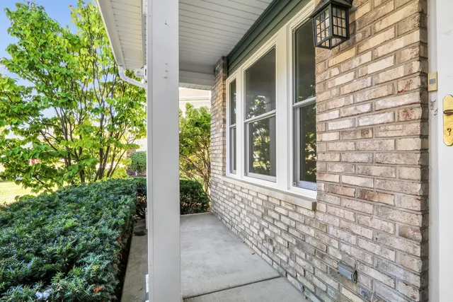 a yellow house with a big yard and large trees