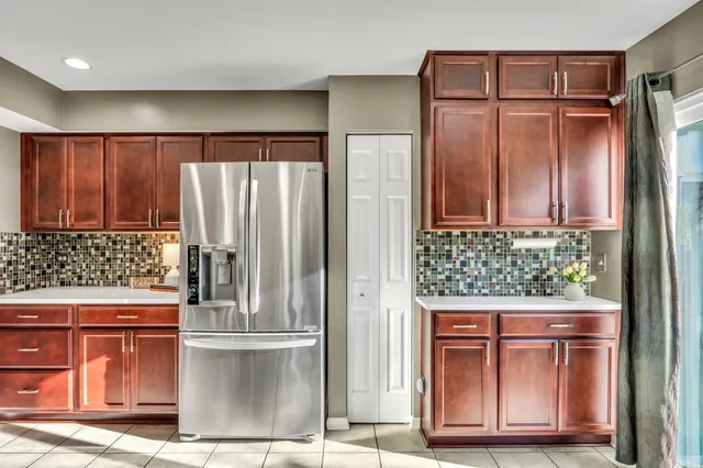 a kitchen with stainless steel appliances granite countertop a refrigerator and wooden cabinets