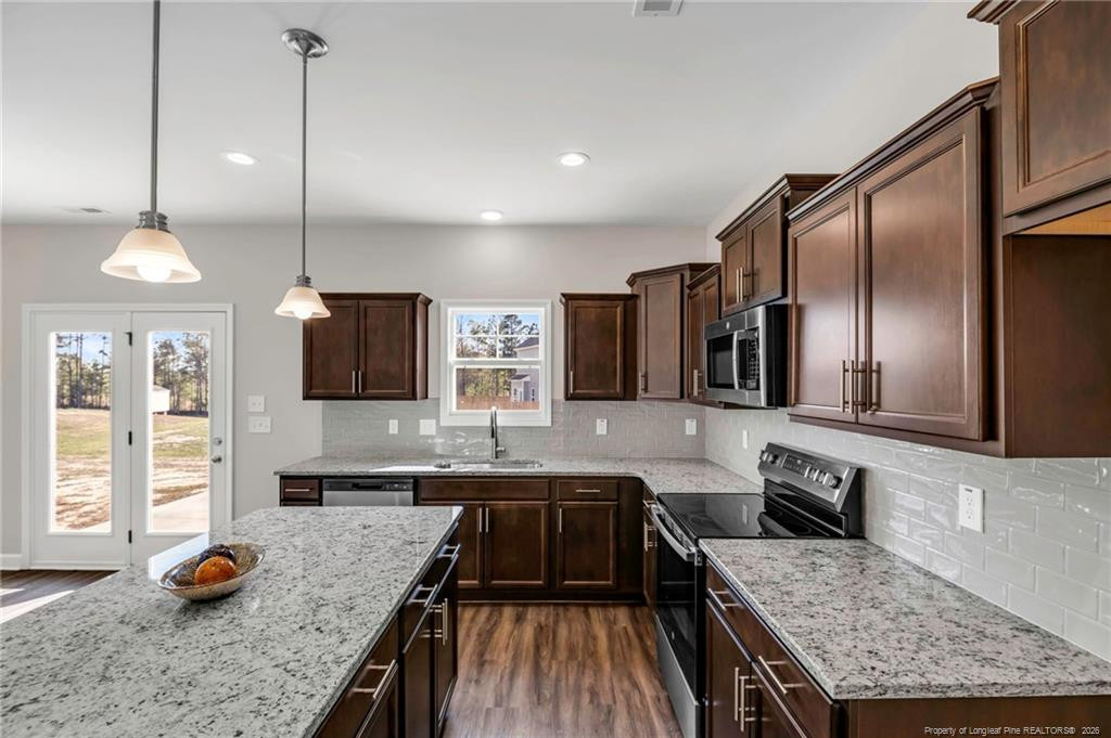 64 Onslow Court Spring Lake, NC 28390 - Photo 12 of 37 a kitchen with granite countertop kitchen island stainless steel appliances a sink stove and refrigerator