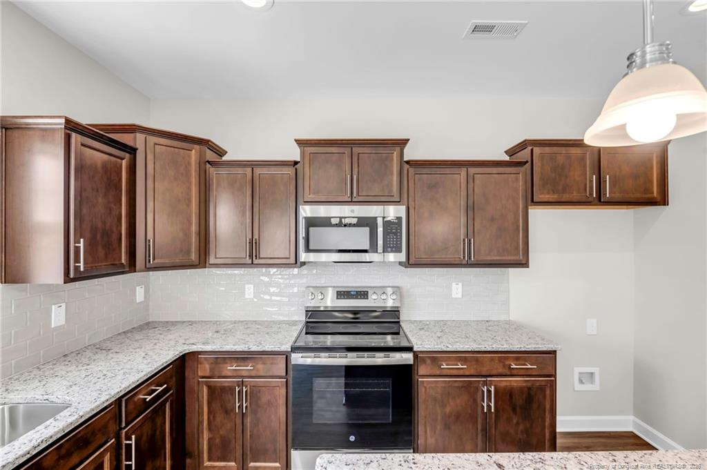 64 Onslow Court Spring Lake, NC 28390 - Photo 15 of 37 a kitchen with granite countertop a stove and a sink
