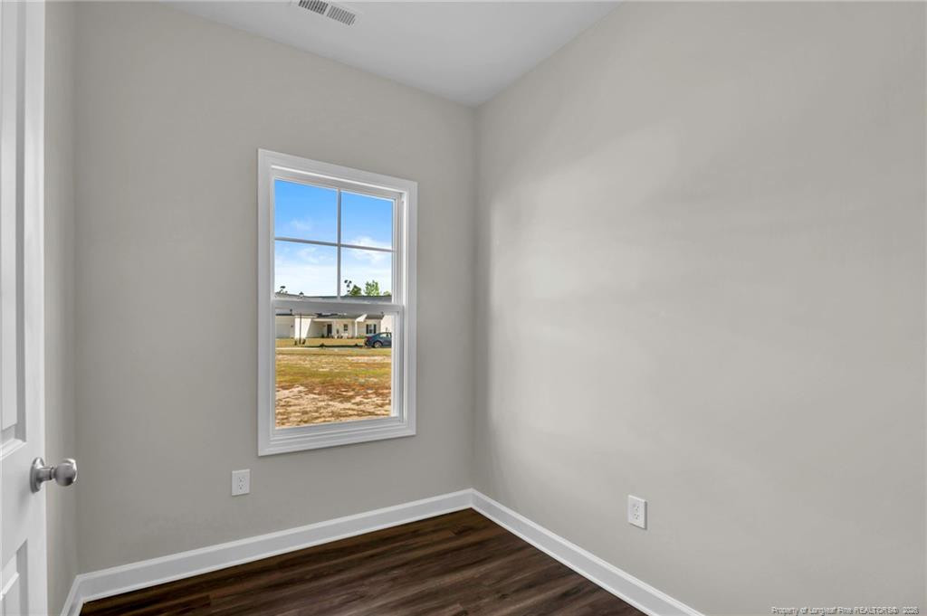 64 Onslow Court Spring Lake, NC 28390 - Photo 5 of 37 a view of an empty room with wooden floor and a window