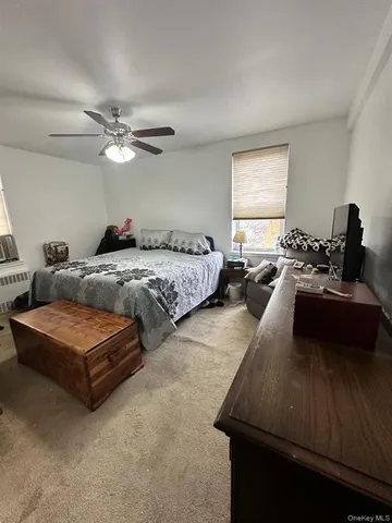 a living room with furniture ceiling fan and a window
