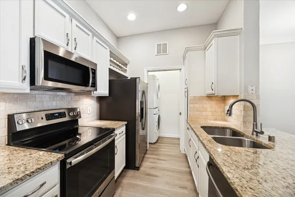 a kitchen with stainless steel appliances granite countertop a sink stove and refrigerator
