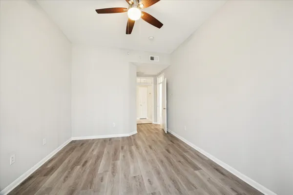 a view of an empty room with wooden floor