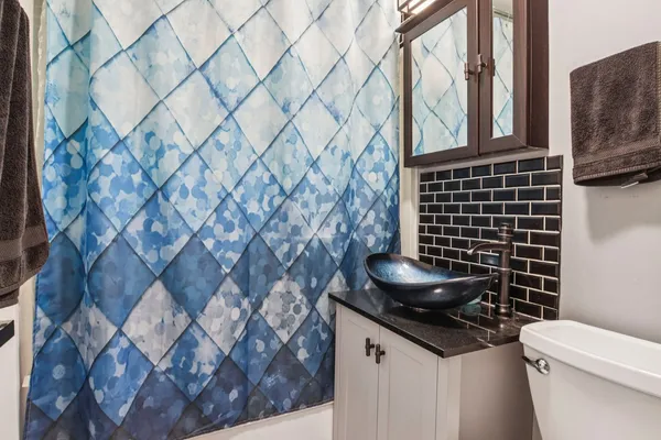 a bathroom with a granite countertop toilet and sink
