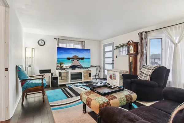 a living room with furniture fireplace and a large window
