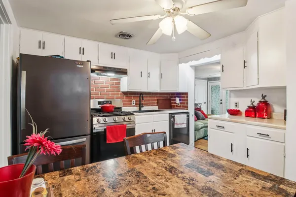 a kitchen with refrigerator and cabinets