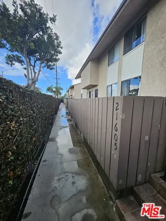 a view of a pathway of a house with wooden fence