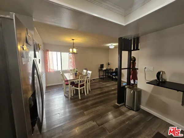 a kitchen with stainless steel appliances a dining table chairs and a refrigerator