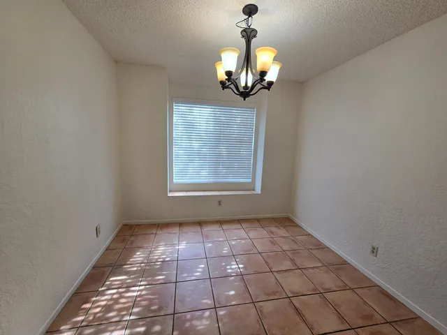 a view of a livingroom with a chandelier fan and windows