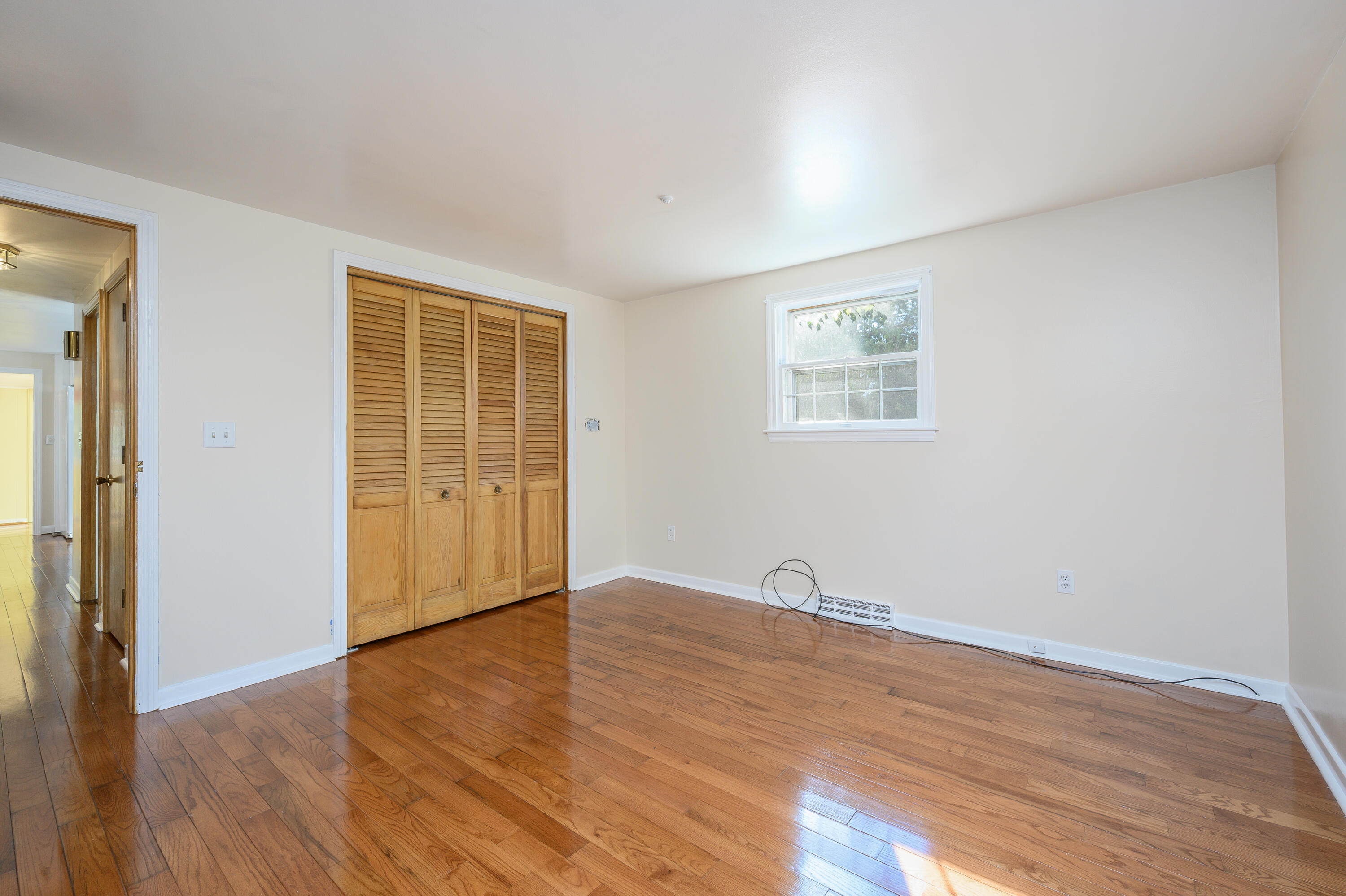 906 Shore Road Pocasset, MA 02559 - Photo 13 of 38 an empty room with wooden floor and windows