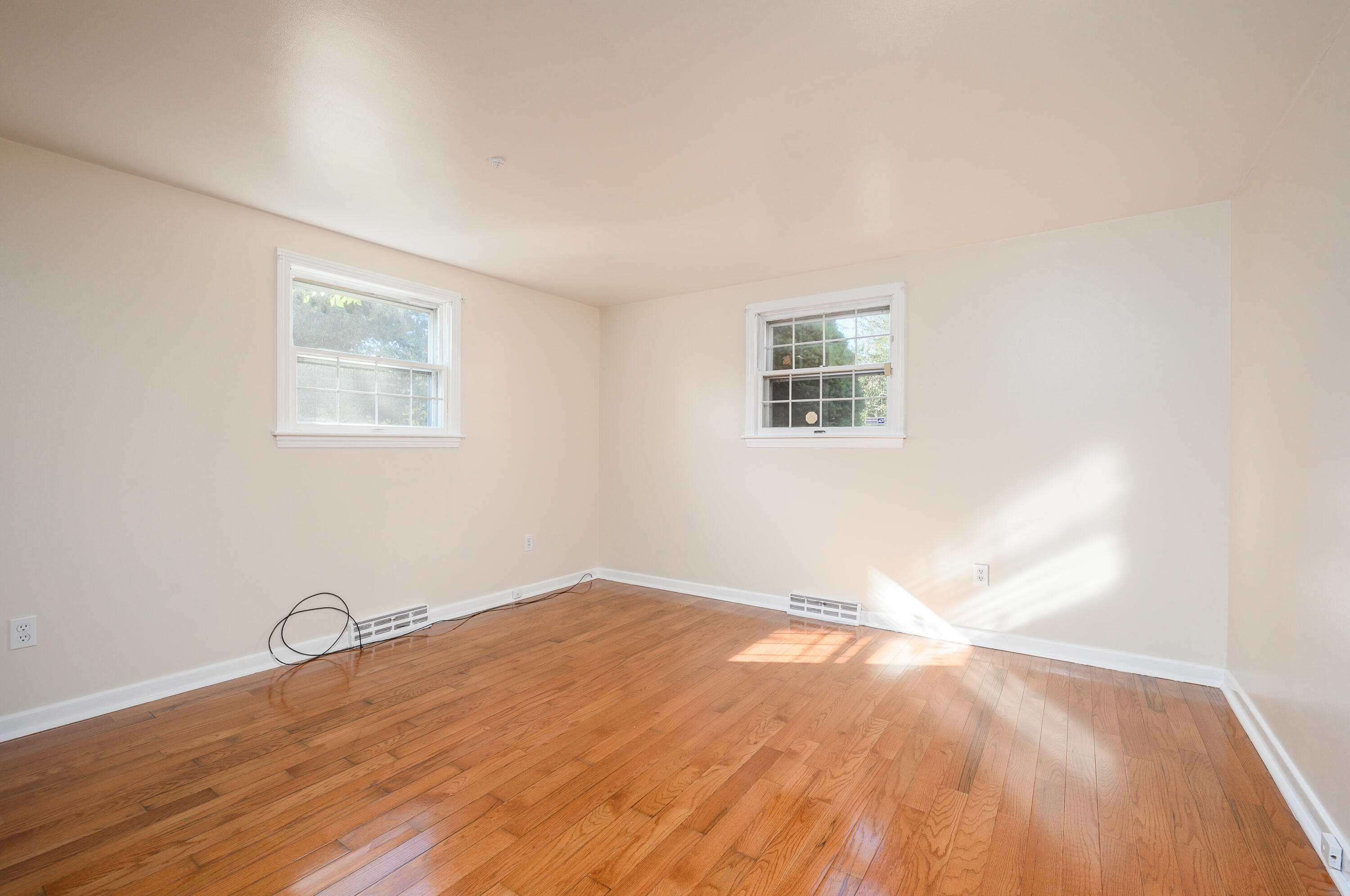 906 Shore Road Pocasset, MA 02559 - Photo 14 of 38 a view of empty room with wooden floor and fan