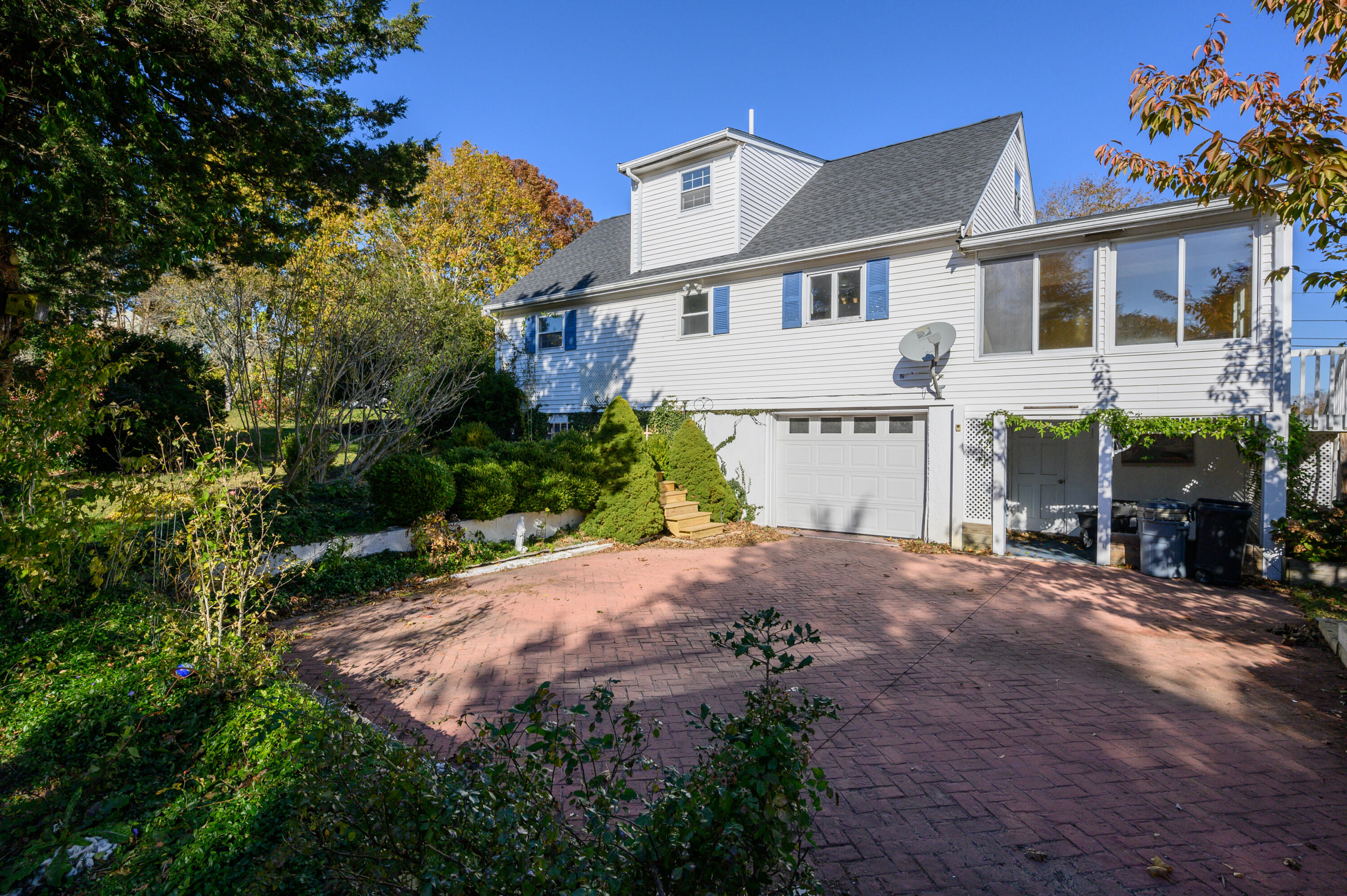 906 Shore Road Pocasset, MA 02559 - Photo 23 of 38 a front view of a house with a yard and garage