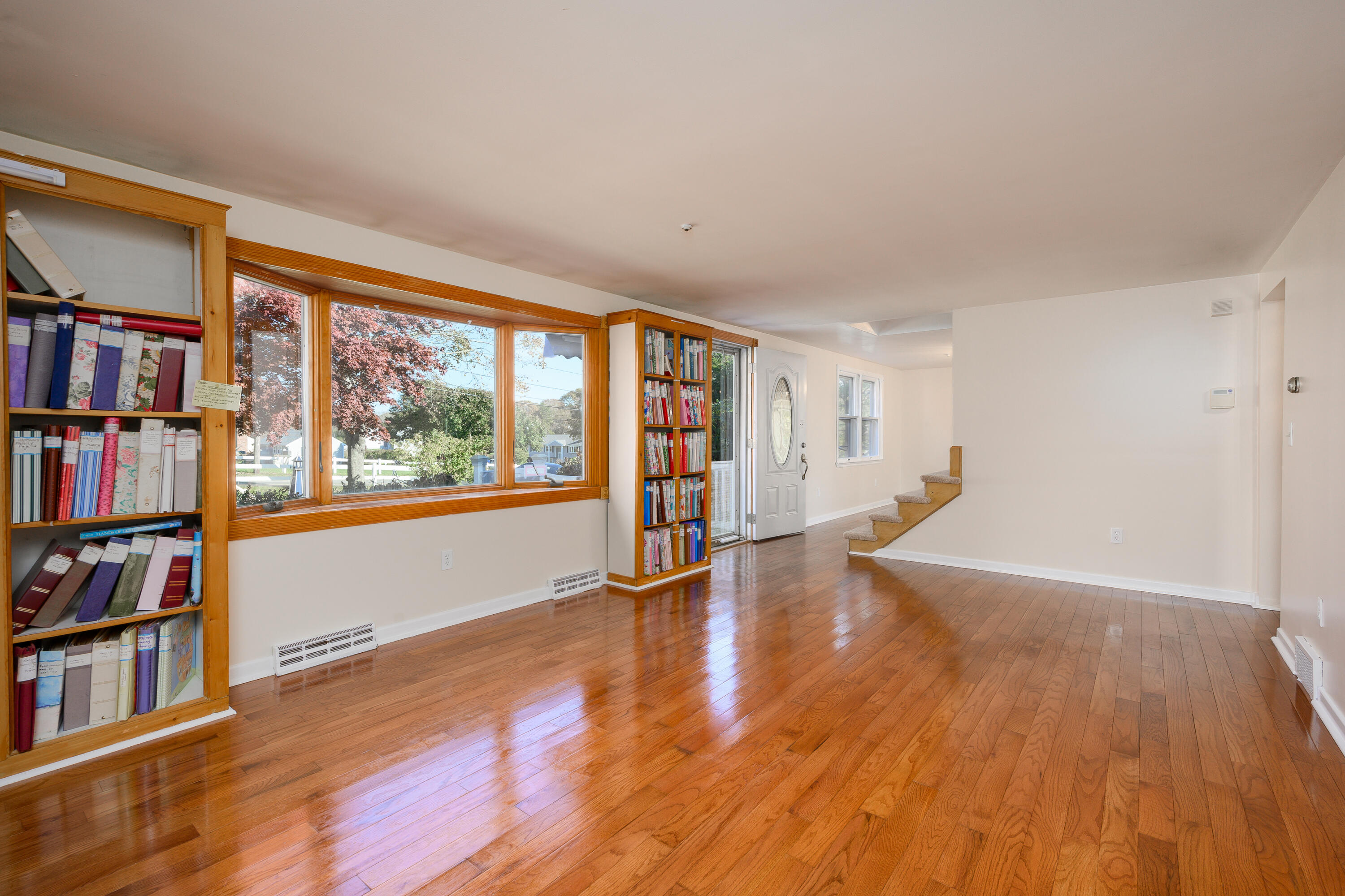 906 Shore Road Pocasset, MA 02559 - Photo 5 of 38 a view of an empty room with bookshelf and wooden floor