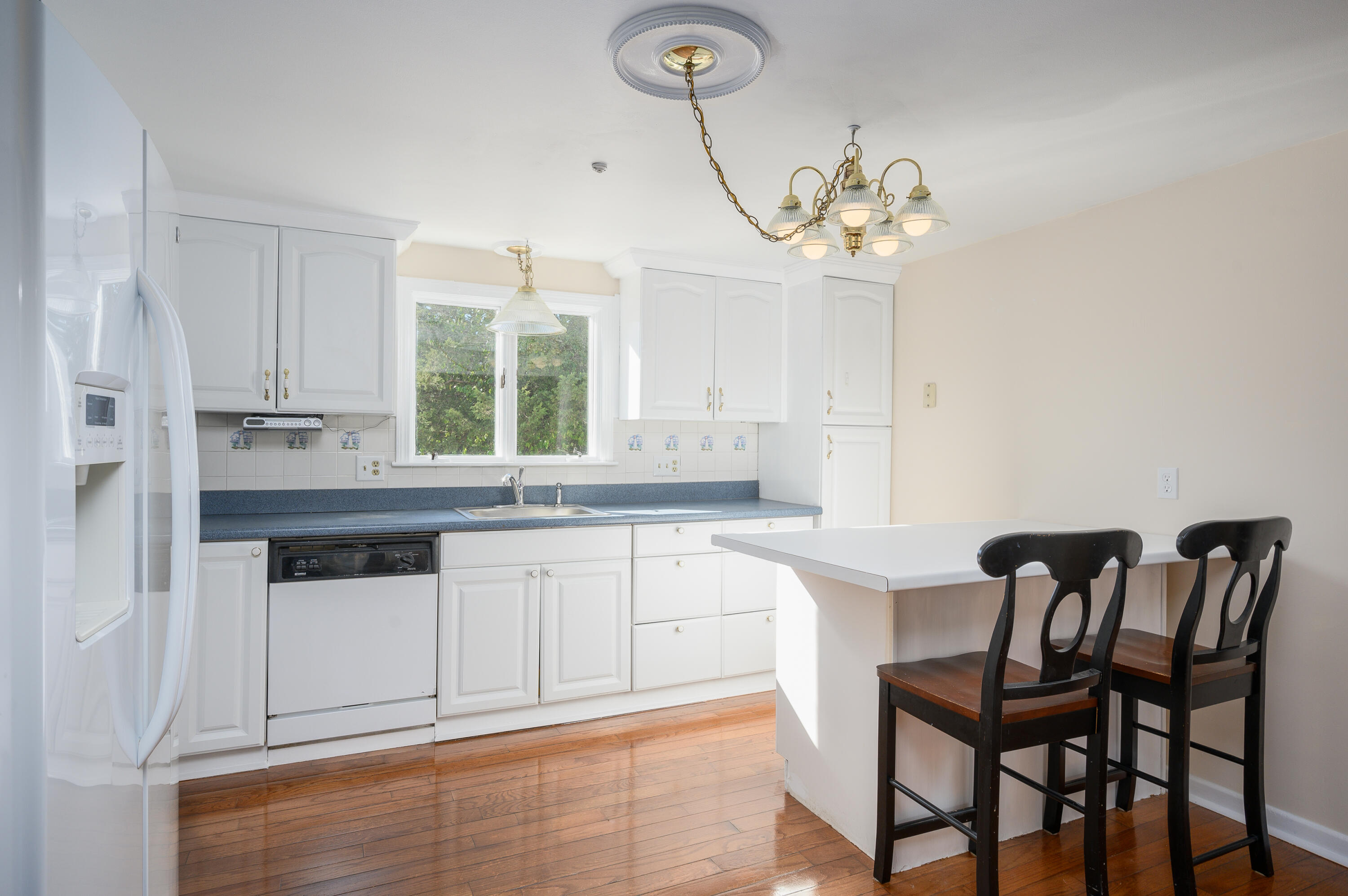 906 Shore Road Pocasset, MA 02559 - Photo 8 of 38 a kitchen with a white cabinets and chairs