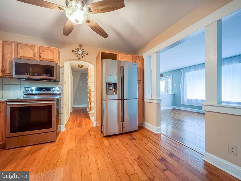 10 Makefield Road Morrisville, PA 19067 - Photo 11 of 46 a kitchen with stainless steel appliances wooden floor and chandelier