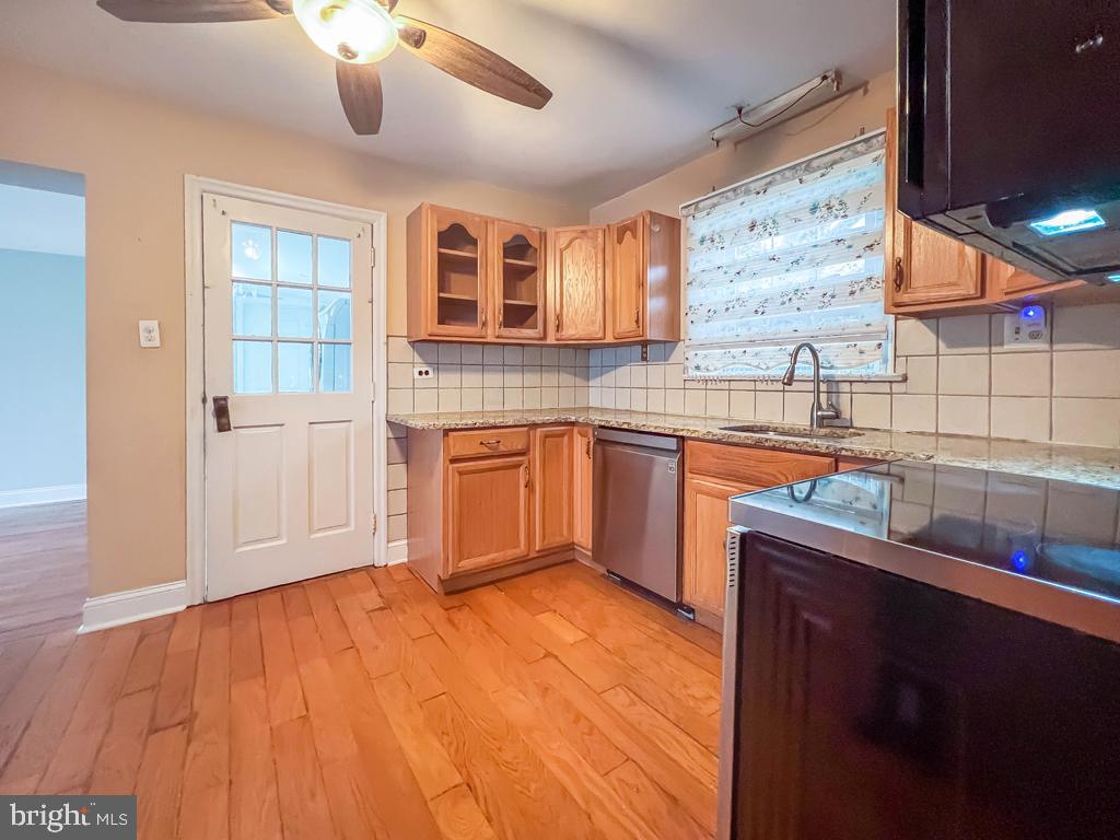 10 Makefield Road Morrisville, PA 19067 - Photo 7 of 46 a kitchen with stainless steel appliances granite countertop a sink dishwasher and wooden cabinets with wooden floor