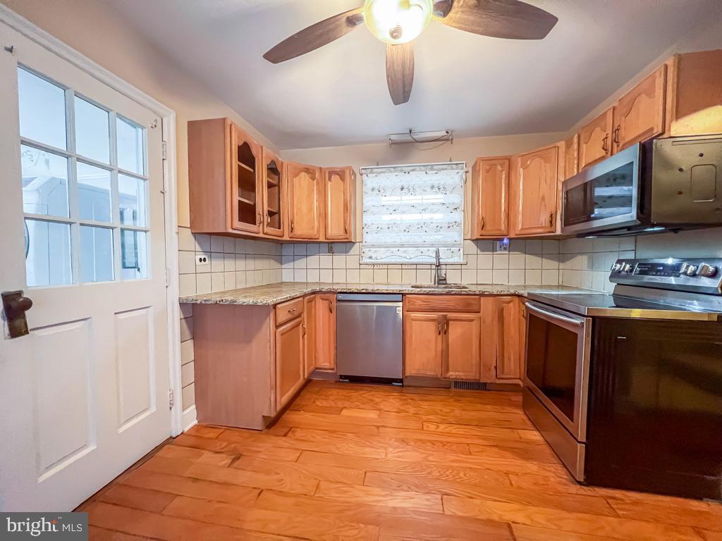 10 Makefield Road Morrisville, PA 19067 - Photo 8 of 46 a kitchen with stainless steel appliances granite countertop a sink cabinets and wooden floor