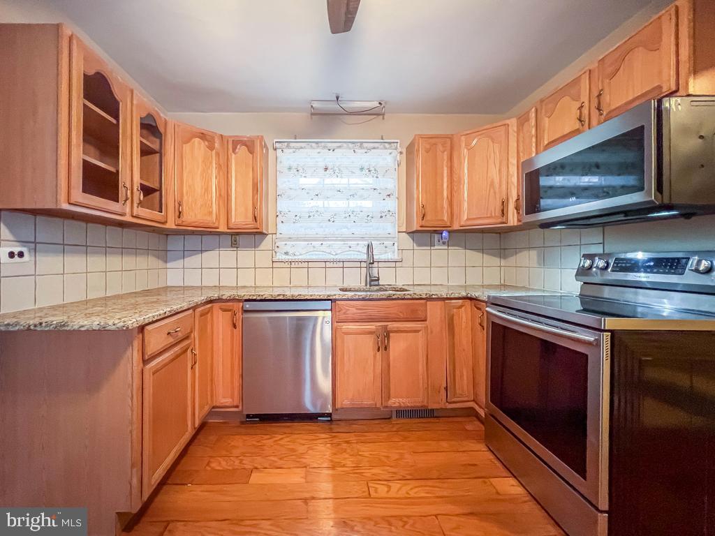 10 Makefield Road Morrisville, PA 19067 - Photo 9 of 46 a kitchen with stainless steel appliances granite countertop wooden cabinets a sink and a stove