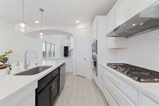 a kitchen with granite countertop a sink stove and cabinets