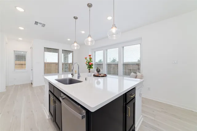 a room with kitchen island a sink and wooden floor