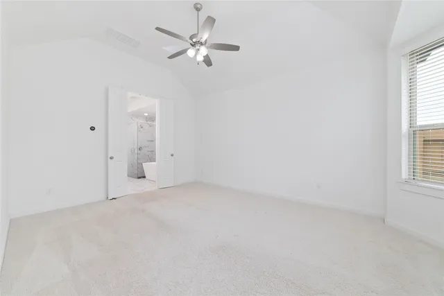 an empty room with windows and fan