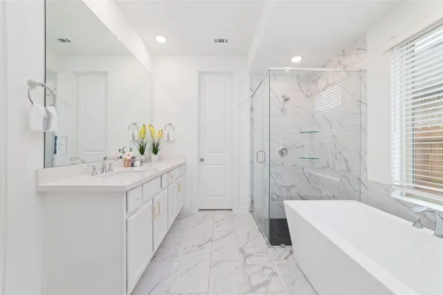 a bathroom with a double vanity sink a mirror a bathtub and shower