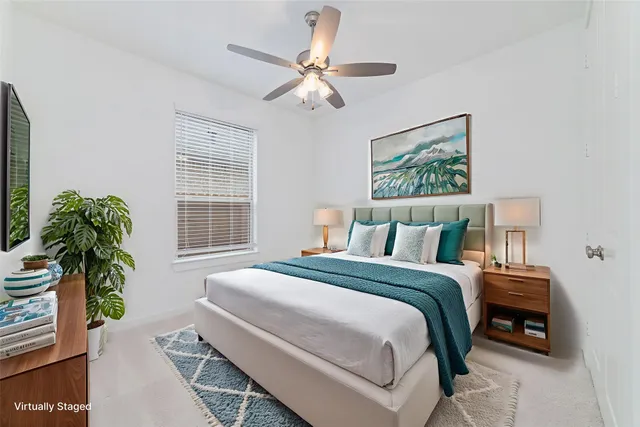 a bedroom with bed and a large window