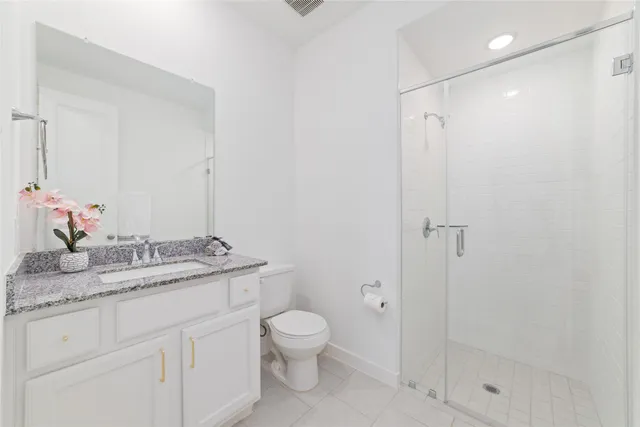 a bathroom with a granite countertop sink toilet a mirror and shower