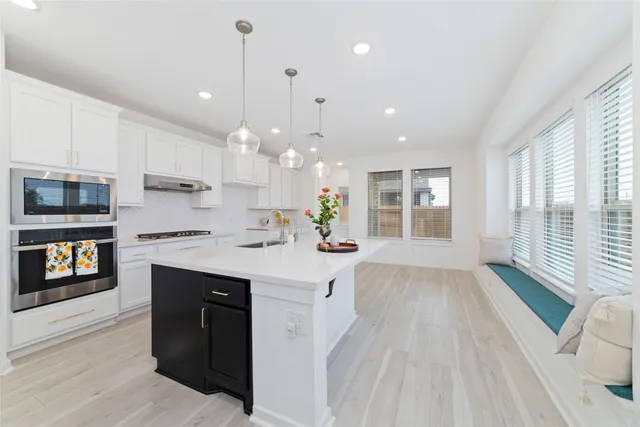 a kitchen with granite countertop a stove a sink a refrigerator and a wooden cabinets