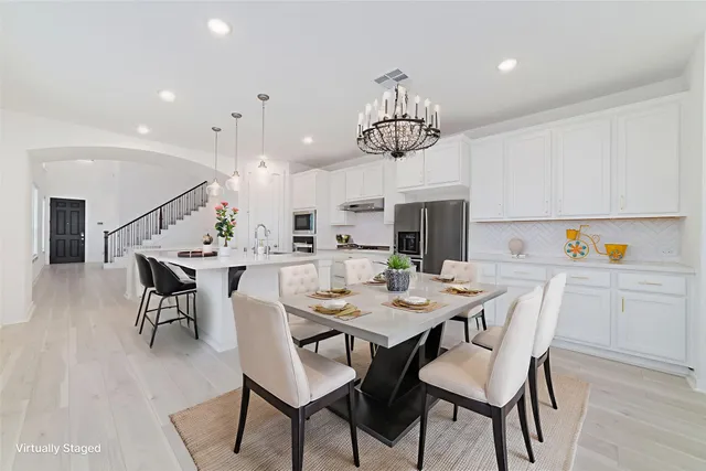 a view of a dining room with furniture wooden floor and chandelier