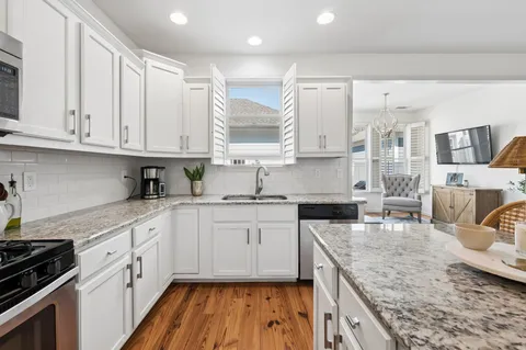 a kitchen with granite countertop a sink stove and cabinets
