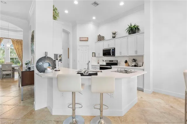 a kitchen with stainless steel appliances kitchen island granite countertop a stove a sink and a refrigerator