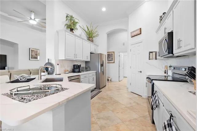 a kitchen with kitchen island a white counter top space cabinets and stainless steel appliances