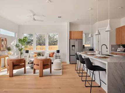 a living room with furniture a large window and wood floor