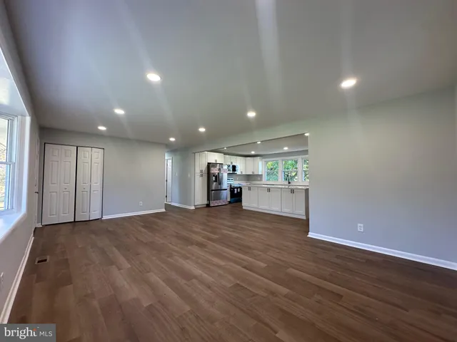 a view of empty room with wooden floor and window