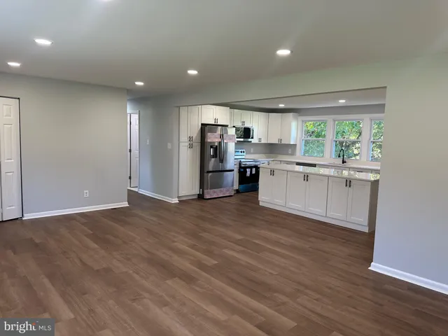 a kitchen with stainless steel appliances a kitchen island hardwood floor sink and stove