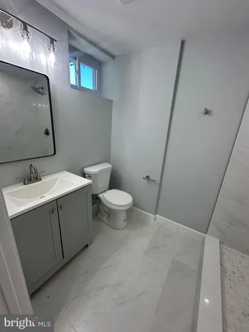 a bathroom with a sink toilet and a mirror