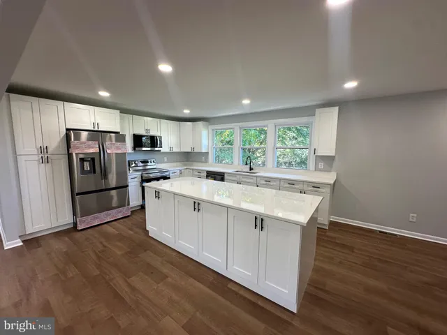 a kitchen with a sink stainless steel appliances and window