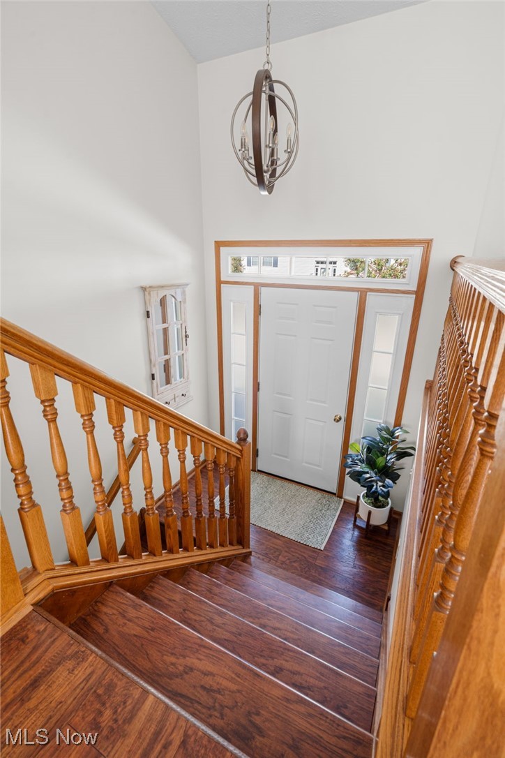64 River Ridge Lane Munroe Falls, OH 44262 - Photo 4 of 25 Foyer with stairway, dark wood-style flooring, a towering ceiling, and a chandelier